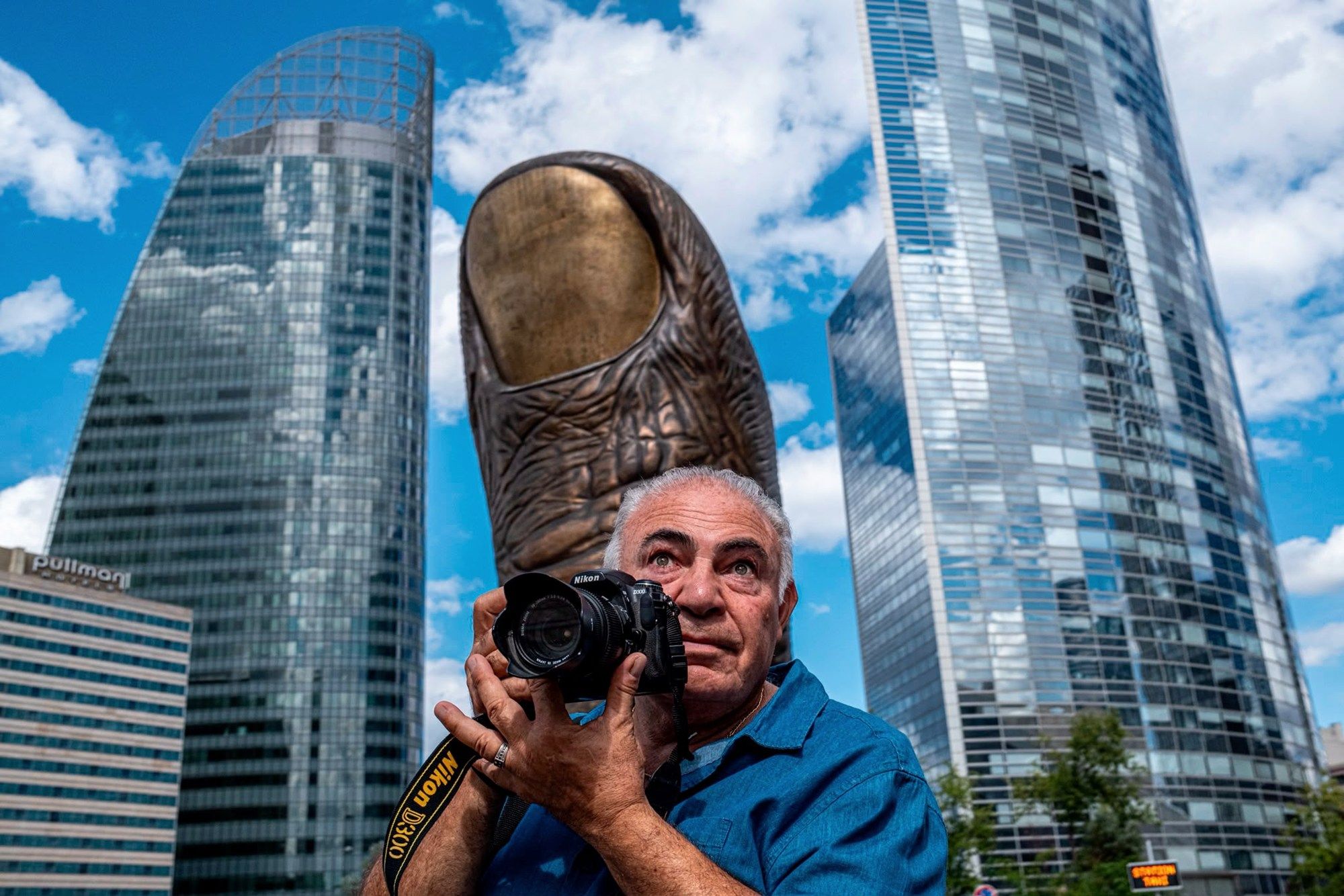 Dev başparmak heykeli önünde fotoğraf çeken adam